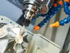 5-axis CNC mill cutting an aluminum impeller with flood coolant during precision CNC machining