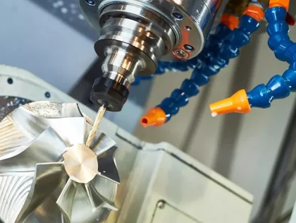 5-axis CNC mill cutting an aluminum impeller with flood coolant during precision CNC machining