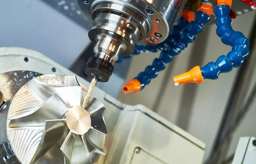 5-axis CNC mill cutting an aluminum impeller with flood coolant during precision CNC machining