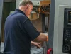 CNC machinist operating a CNC machining center in a manufacturing workshop